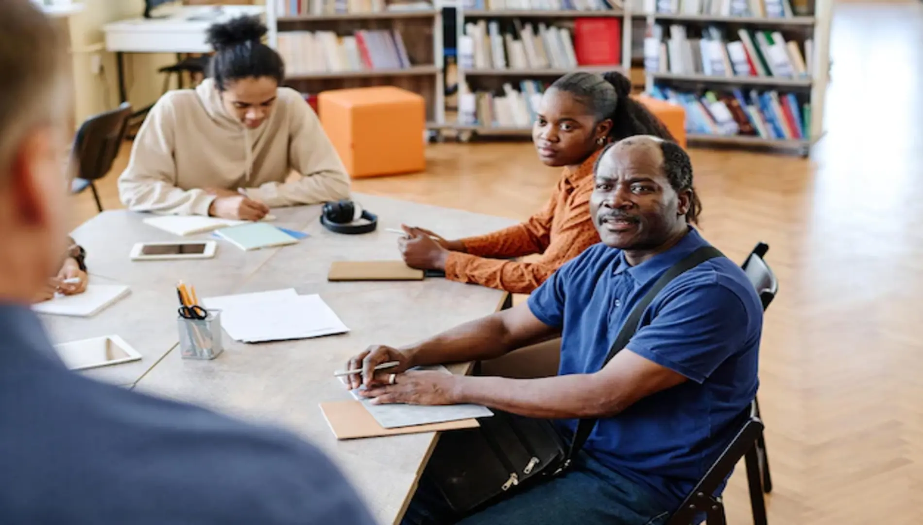 Adult Education is ongoing in a classroom, with adults fully concentrating.